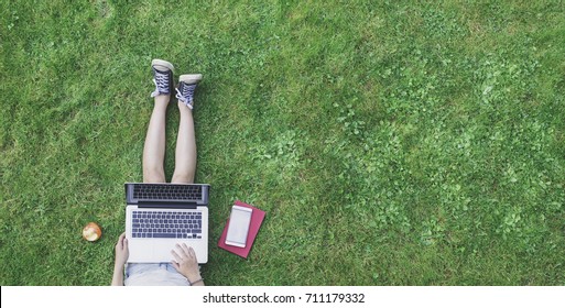 Top View Photo Of Girl In Grass Using Laptop