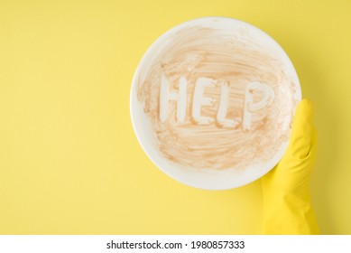 Top View Photo Of Hand In Yellow Rubber Glove Holding Dirty Dish With Inscription Help On Isolated Yellow Background With Copyspace