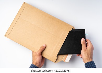 Top view photo of male hands   hold (open) an envelope above white background