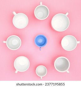Top view photo of plenty variety of clean white elegant porcelain coffee or tea cups und one blue plastic cup. Concept of food, holiday, table setting, retro, vintage, etiquette, ethics, decorum