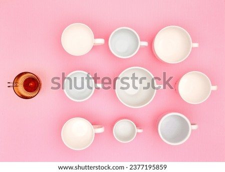 Top view photo of plenty variety of clean white elegant porcelain coffee or tea cups und one red glass cup. Concept of food, holiday, table setting, retro, vintage, etiquette, ethics, decorum
