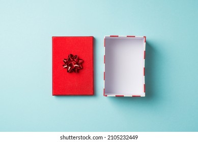 Top view photo of valentine's day decorations open empty giftbox with red lid and star bow on isolated pastel blue background with copyspace