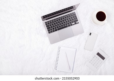 Top View Photo Of White Calculator Pen And Notebook, Grey Laptop And Cup Of Coffee On A Soft White Blanket. Flatlay, Concept Freelance, Rest And Work Place