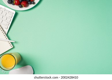 Top view photo of workplace keyboard mouse reminder pen clip glass of beverage blueberries and strawberries on plate on isolated turquoise background with copyspace - Powered by Shutterstock