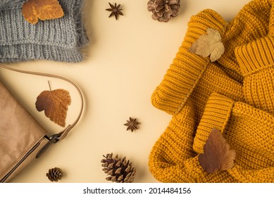 Top view photo of yellow sweater grey knitted scarf leather handbag autumn brown leafage anise and pine cones on isolated light beige background - Shutterstock ID 2014484156