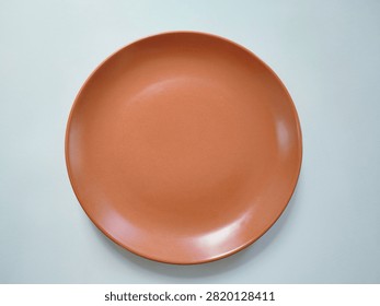 Top view photograph of an empty ceramic plate isolated on a white background. Suitable for food presentation mockups, menu design, restaurant, kitchen, tableware, and dining concepts.