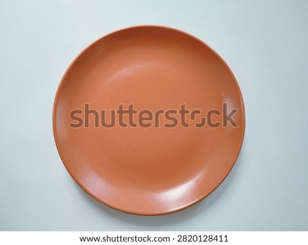 Top view photograph of an empty ceramic plate isolated on a white background. Suitable for food presentation mockups, menu design, restaurant, kitchen, tableware, and dining concepts.