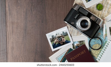 Top view of Photographs of woman taking photos, passports, old photo camera, map and notebook on a dark wooden table - Powered by Shutterstock