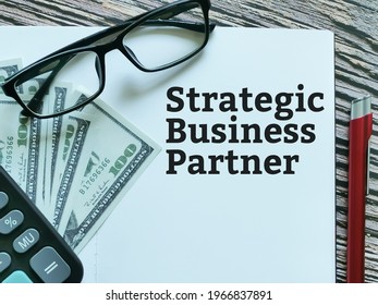 Top View Phrase Strategic Business Partner Written On Notebook With A Pen,calculator And Eye Glasses.