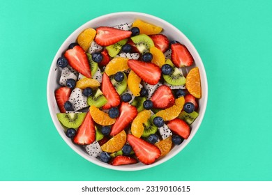 Top view picture of healthy fruit salad bowl on green background. - Powered by Shutterstock