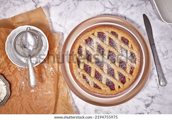 Top view of pie called \'Linzer Torte\', a\
traditional Austrian shortcake pastry topped with fruit preserves\
and nuts with lattice\
design