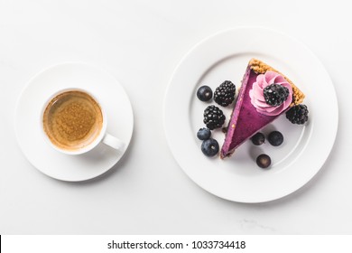 Top View Of Piece Of Cake With Berries And Cup Of Coffee Isolated On White Tabletop