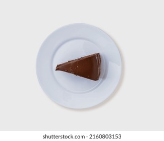 Top View A Piece Of Chocolate Cake On Round White Plate Isolated On White Background, Clipping Path, Studio Shot, Bekery And Dessert Concept