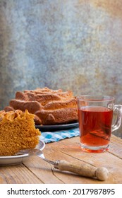 Top View Of Piece Of Yogurt Sponge Cake On Plate With Fork, Glass With Rooibos Tea, On Rustic Table, In Vertical, With Copy Space