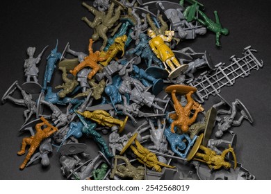 Top view of a pile of toy soldiers on a grey background, chaos never dies day - Powered by Shutterstock