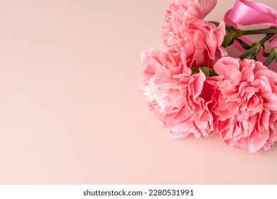 Top view of pink carnations and pink ribbon for mother's day