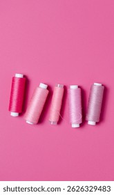 Top view of pink thread spools background