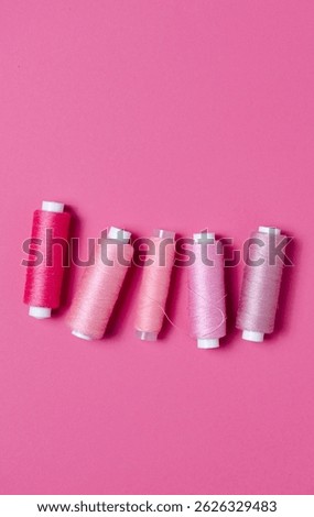 Top view of pink thread spools background