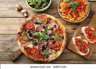 top view pizza pasta with tomato sauce and salad bowl on rustic table