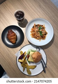 Top View, Plant Based Burger With Sweet Potato Fries, Croissant, Coffee, Spaghetti.