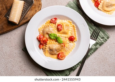 Top view of a Plate with creamy Italian Ravioli with tomatoes and cheese. Beige table surface. - Powered by Shutterstock