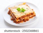 Top view of a plate of lasagna with layers of meat sauce and cheese, isolated on white background