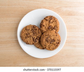 Top View Of A Plate Of Milk Chocolate Chip Cookies On A Wood Table Illuminated With Natural Light.