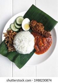 Top View Of A Plate Of Nasi Lemak With Chicken Rendang. Nasi Lemak Is A Malaysian Popular Favourite Food. Traditionally Nasi Lemak Is Wrapped With Banana Leaf.