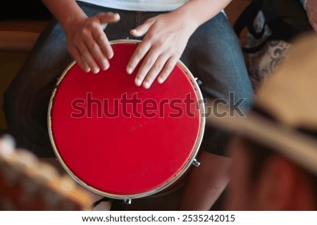 top view, playing, atabaque, red, between, legs