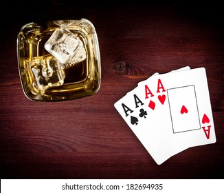 top of view of poker playing cards near whiskey glass on old wood table