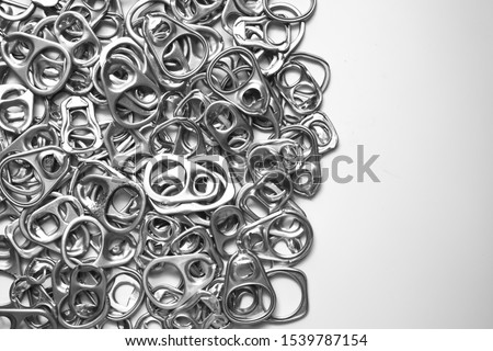 Top view of pool or many of silver metal ring pull or pull tab lid for bottle or can opener on white background , recycle or eco and environmental friendly concept with copy space 