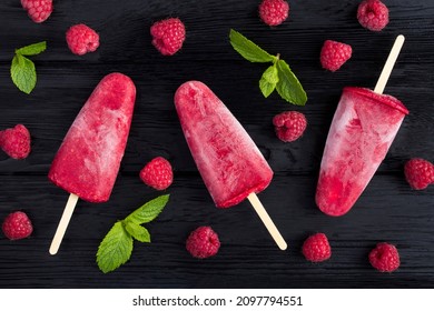 Top view of popsicles with raspberry on the black wooden  background. Close-up.