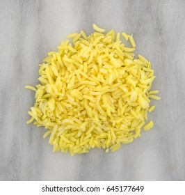 Top view of a portion of cooked pilau rice on a marble cutting board.