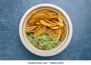 A top view of a portion of fried plantain chips with guacamole