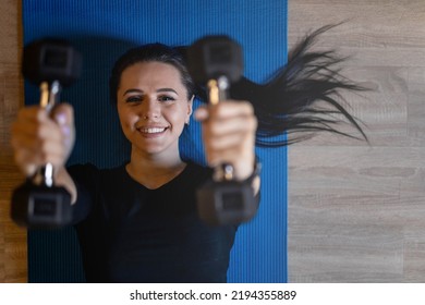Top view portrait beautiful brunette sports woman lying on floor mat holding dumbbells exercising at gym. Closeup happy female training muscles fitness bodybuilding physical activity healthy lifestyle - Shutterstock ID 2194355889
