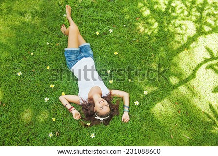 top view portrait of a pretty young woman relaxing on a grass