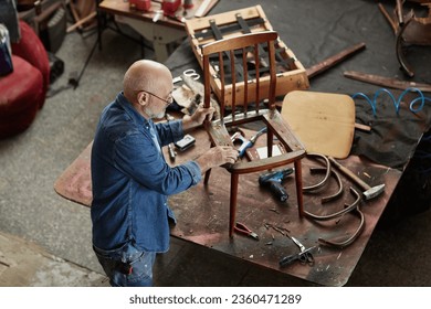 Top view portrait of senior artisan fixing old furniture in workshop, copy space - Powered by Shutterstock