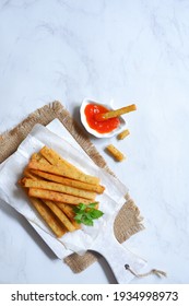 Top View Of Potato Cheese Stick In A Wooden Coaster Against White Background