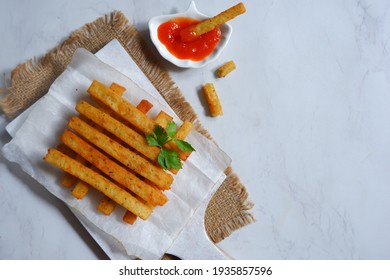 Top View Of Potato Cheese Stick In A Wooden Coaster Against White Background