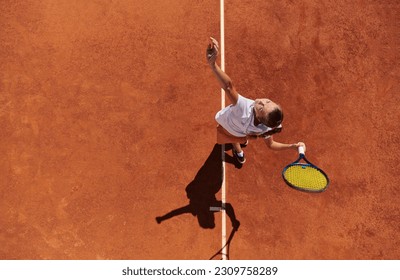 Top view of a professional female tennis player serves the tennis ball on the court with precision and power - Powered by Shutterstock