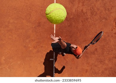 Top view of a professional tennis player serves the tennis ball on the court with precision and power - Powered by Shutterstock