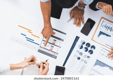 Top view project manager communicate and collaborate with team using project management software, tracking progress of project task and making schedule plan at meeting table. Prudent