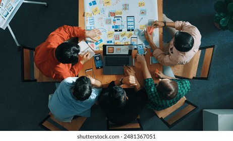 Top view of project manager using laptop working on Ux Ui design for mobile phone interface while marketing team designing software program by using brainstorming mind map. Top view. Convocation. - Powered by Shutterstock