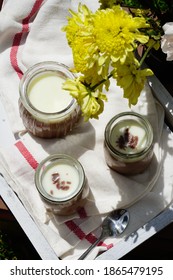 Top View Of Puding Coklat Or Chocolate Pudding Or Panna Cotta In Sunny Day As Outdoor Meal With Yellow Flowers In The Table