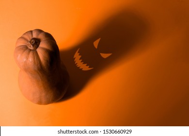 Top View Pumpkin With Shadow With Scary Face On Orange Background Halloween Card