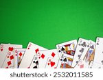 top view of random playing cards on green table. copy space green background