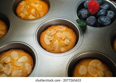 Top view Raspberry and Almond Financier (cake) is a small French almond cake, flavored with beurre noisette, usually baked in a small mold. Moist with a crisp, eggshell-like exterior with copy space