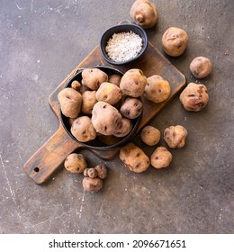 Top View Of Raw Black Potatoes( Papas Negras In Spanish), And Sea Salt,principal Ingredient For  Famous Local Canary Islands Dish, Papas Arrugadas  Or Wrinkly Potatoes.