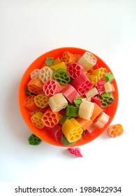 Top view of raw fryums in an orange bowl in isolated white background.