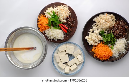 Top view raw material ready to cook homemade rice noodles roll, vegan ingredient as wood ear mushroom, carrot, rice batter, tofu that chopped on white background, Vietnamese popular dish           
